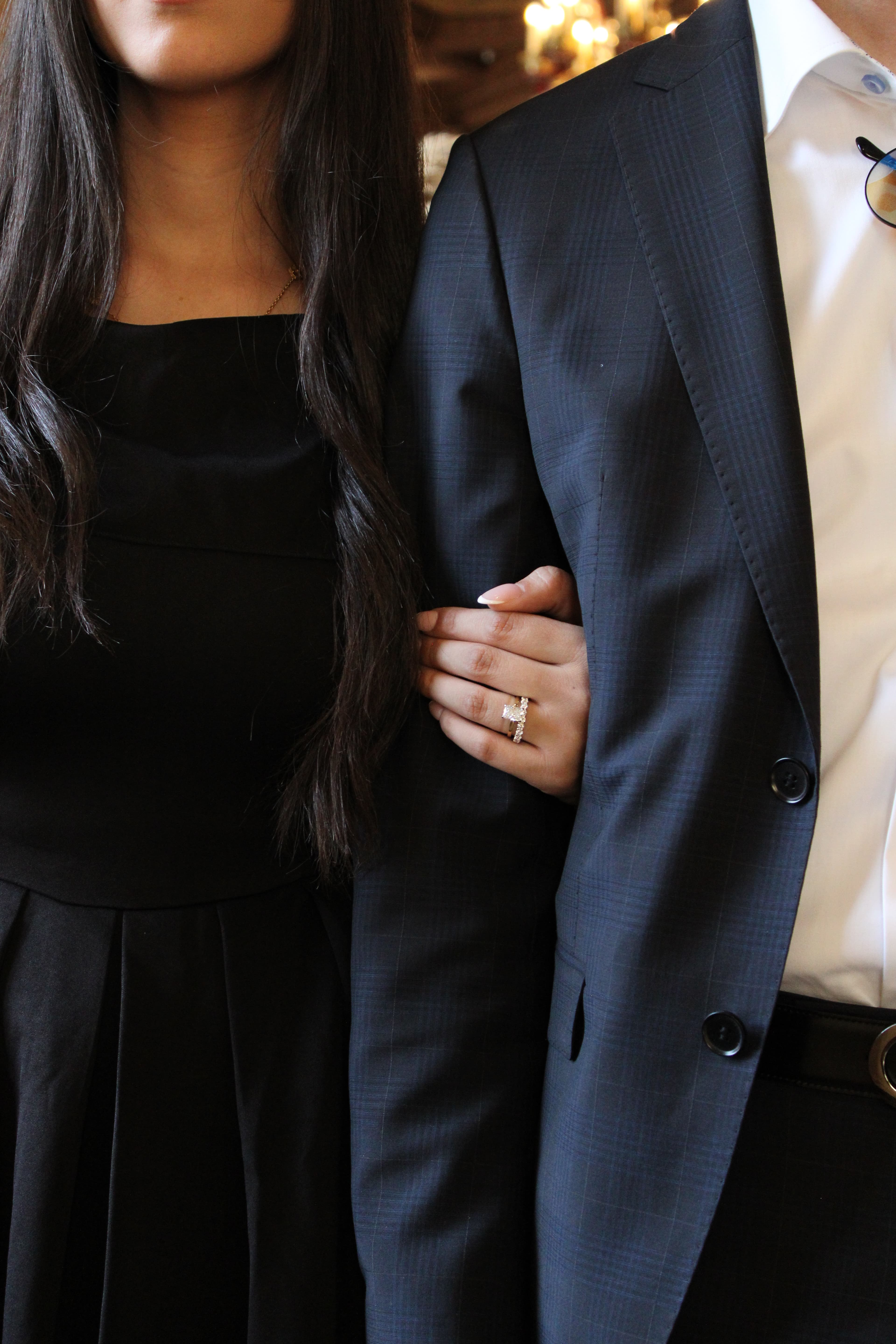 Close-up of a couple's clasped hands showing an engagement ring, photographed by ShuhraBilNoor